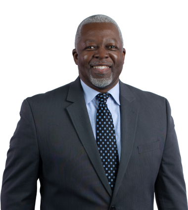 Portrait of an older Black man with gray hair and beard, wearing a suit and tie.
