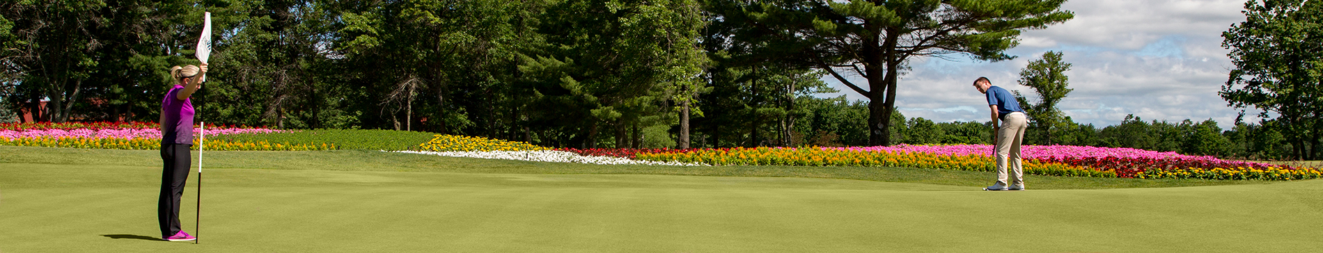 Two players putting on the 16th hole green at SentryWorld