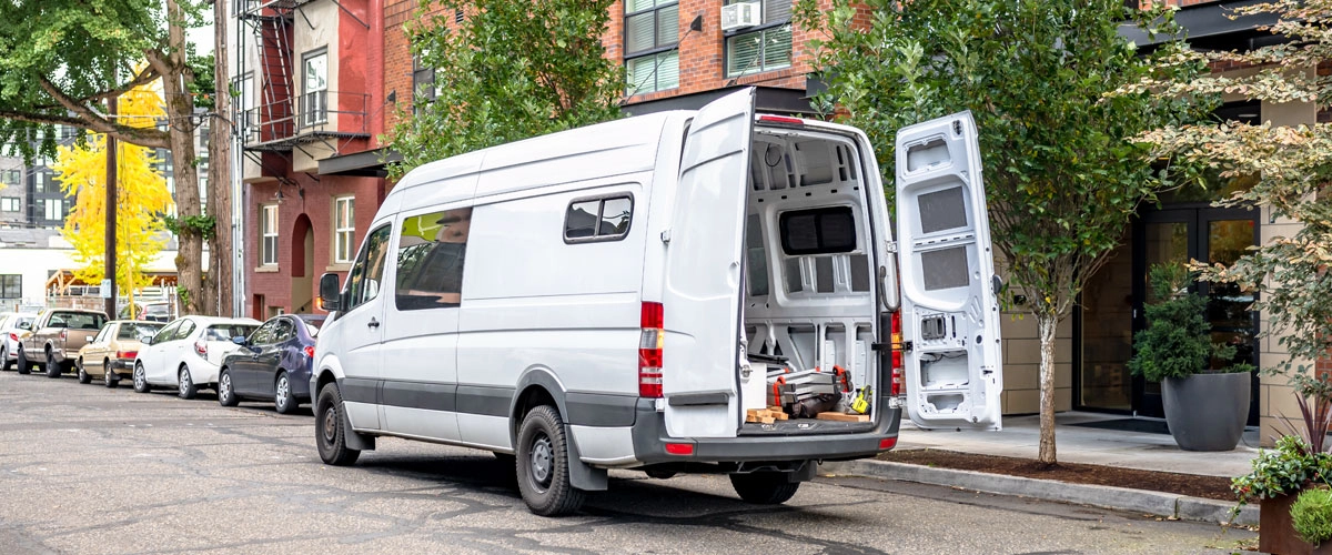 commercial-auto-image-in-city-LG delivery van parked on city street with back doors open