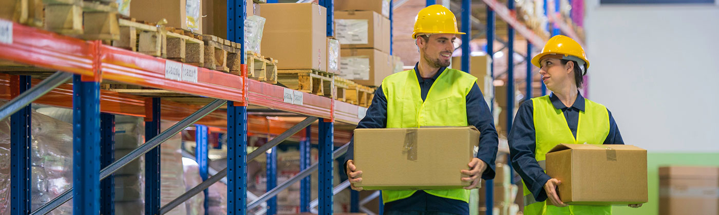 Man and woman in hard hats carrying boxes