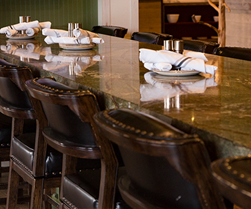 Plates and napkins set out on a long table with chairs