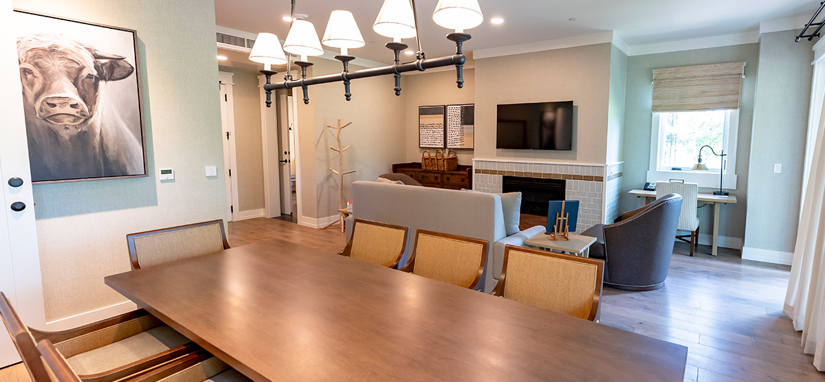 carousel-executive-king-suite-1br-2-1200x556 Executive suite parlor area with dining room table and seating area.