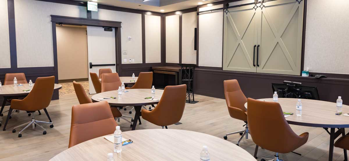 Round tables with notepads and bottles of water in a meeting room at SentryWorld