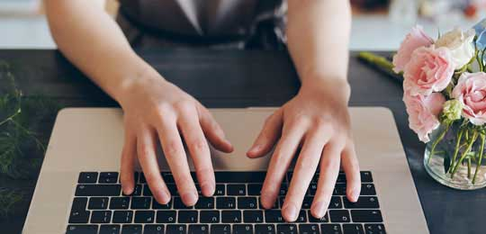 Closeup of someone hands typing on a keyboard