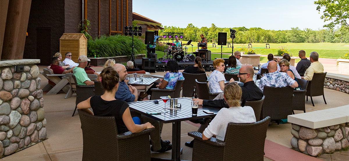 People seated on the PJ's - SentryWorld patio watching a PJ's Live band