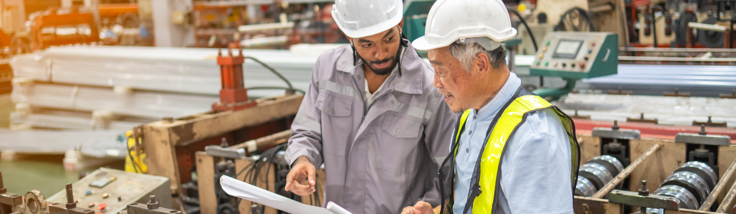 Two manufacture workers overlooking paperwork.