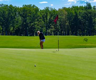 Woman chipping onto practice green at SentryWorld