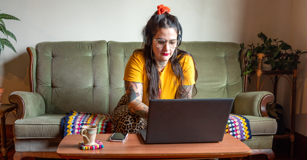 Woman working on laptop while sitting on couch