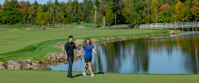 Two golfers walking along the fairway at SentryWorld