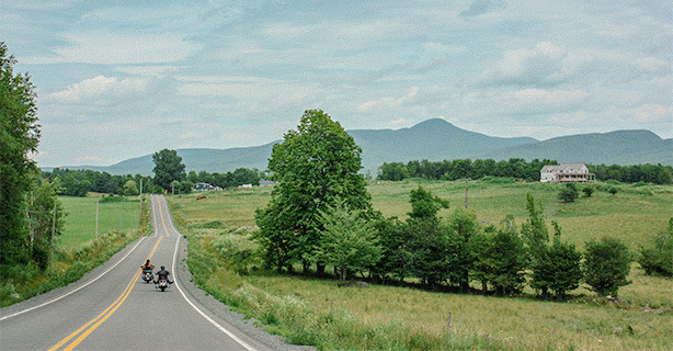 Two motorcycles on long road in the country