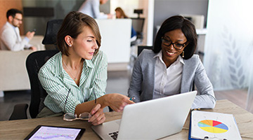 Two women looking at a computer.