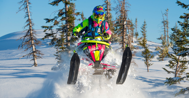 Snowmobiler jumping in snow