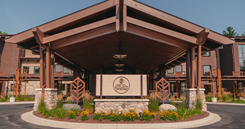 The Inn at SentryWorld front entrance sign with yellow summer flowers below. 