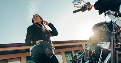 Woman standing by a motorcycle