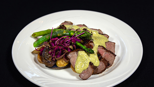 White plate with steak, asparagus, and potatoes