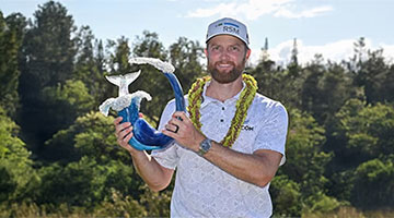 The Sentry tournament winner of 2024, Chris Kirk, holding the tournament trophy