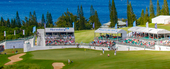 Spectators seated around a putting green during The Sentry golf tournament