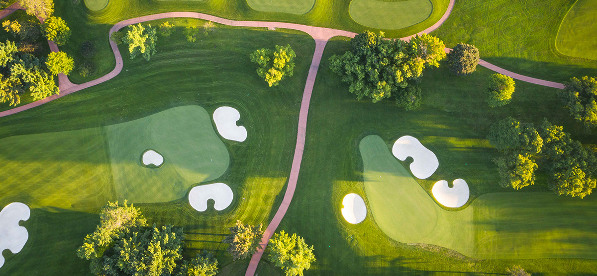 Aerial view of two putting greens and a cart path at SentryWorld