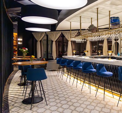 Muse curved white bar area with blue barstools. 