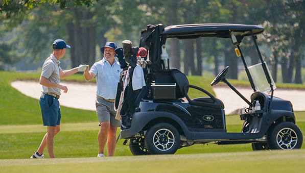 50-50-stay-play-package-597x339 Two male golfers and a golf cart.