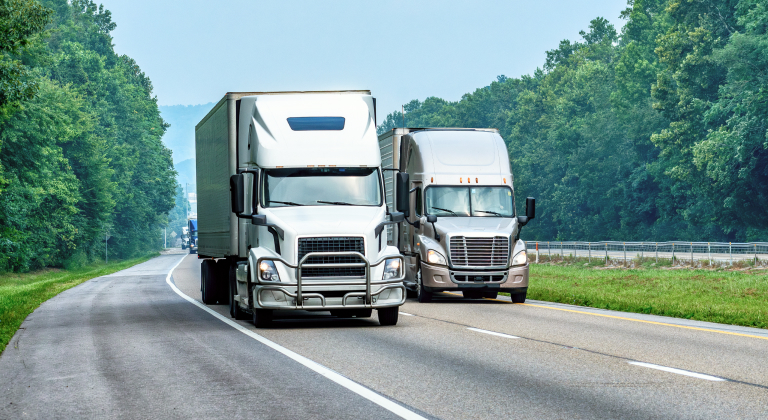 Two semi trucks on an interstate.