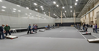 People playing bean bag toss in the SentryWorld fieldhouse