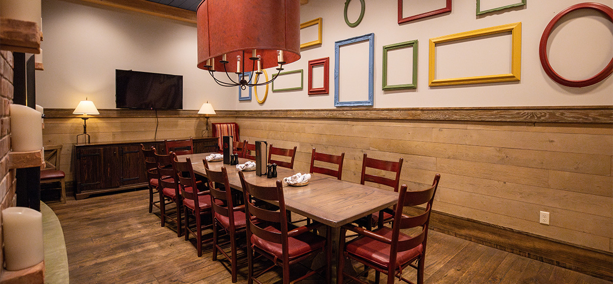 Dining table, TV, and wall art in the Celebration Room at PJ's - SentryWorld