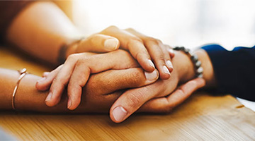 Close up of two people holding hands