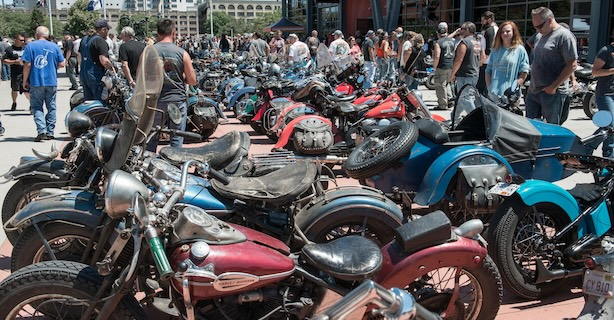 Parked motorcycles with a crowd of people