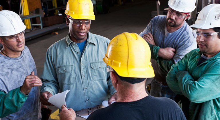 Group of men in hard hats in warehouse