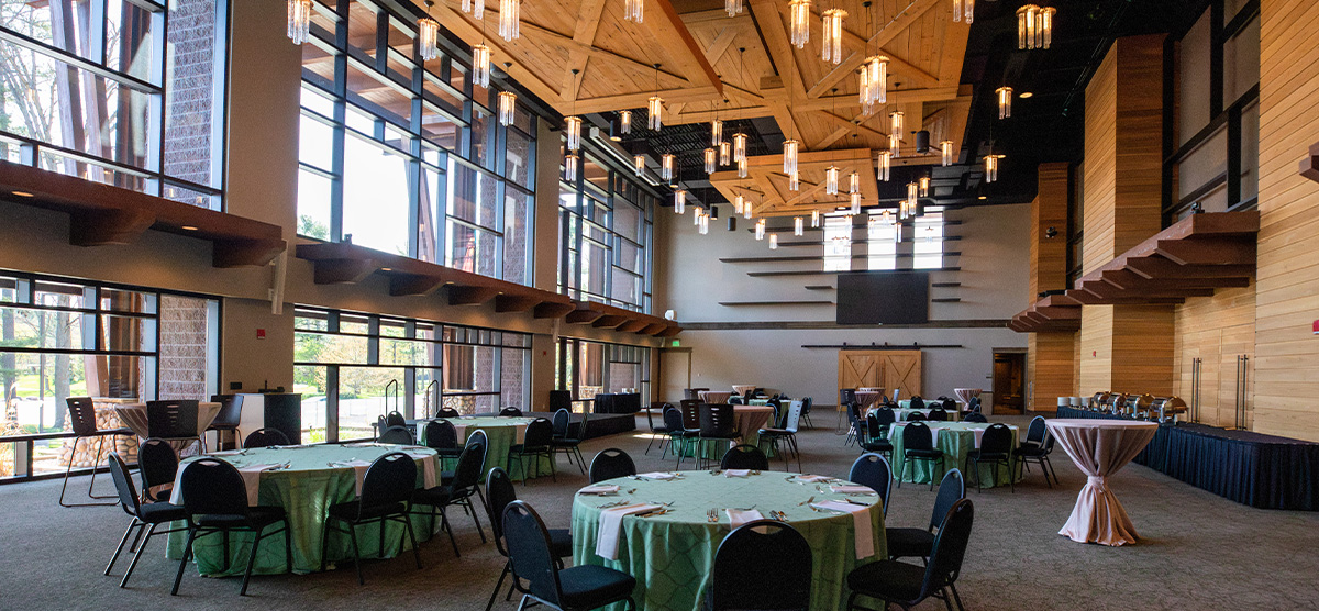 Round tables with green table clothes set for an event in the Atrium at SentryWorld