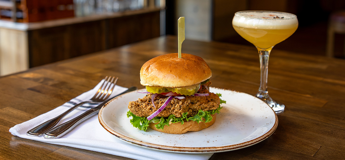 Buttermilk Chicken, pickles, lettuce, tomato, onion, and Nashville aioli on a toasted brioche. 