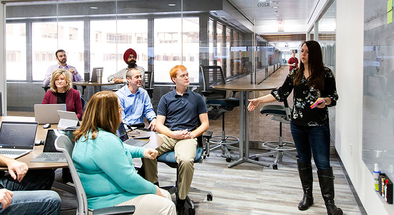 Seven people meeting in a Sentry office room