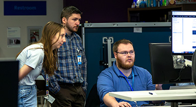 Three co-op students working on a project at the Stevens Point Sentry co-op location.