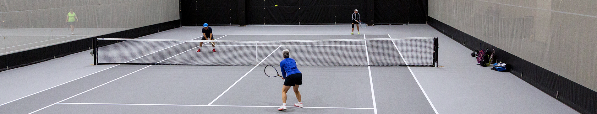 Two people playing tennis in the SentryWorld fieldhouse