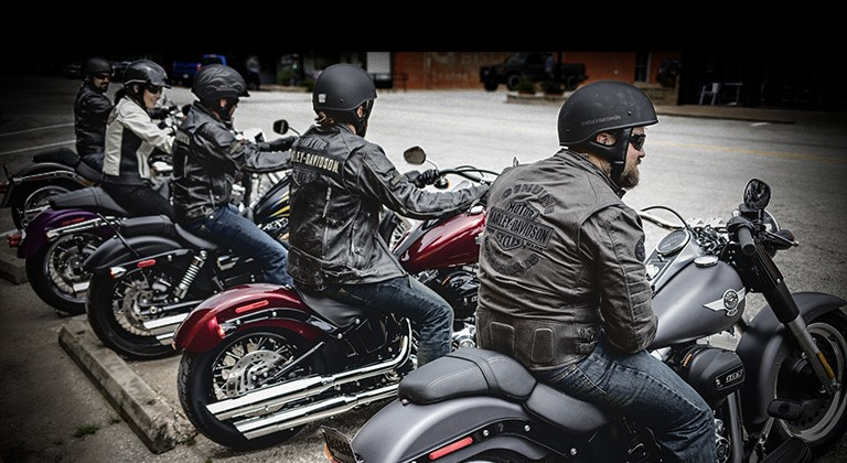 Men and women riding Harley Davidson motorcycles.