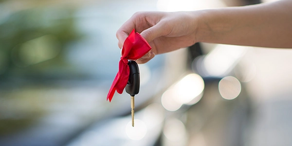car-insurance-for-new-drivers-resource-carousel1-rect hand holding keys with red ribbon