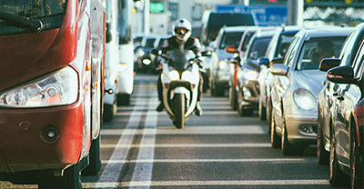 Motorcycle rider navigating between two rows of traffic