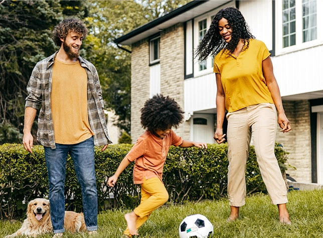 a family playing soccer in their yard