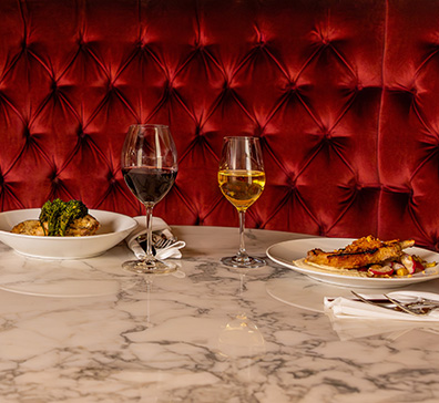Marble table at Muse with two plates and two wine glasses. 