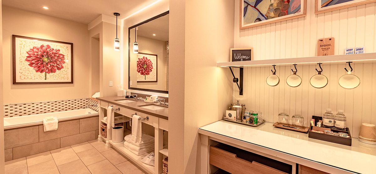 carousel-executive-junior-suite-4-1200x556 Bathroom sink and tub area.