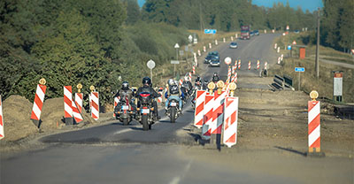 Group of motorcyclists driving through an area under construction