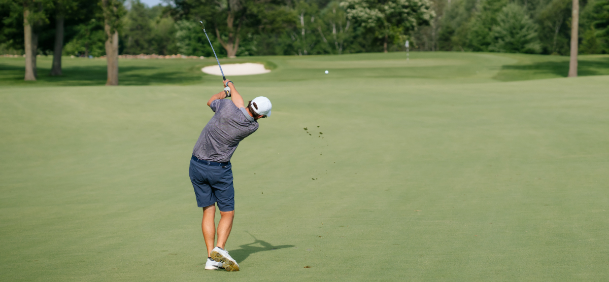 Male golfer in mid swing. 