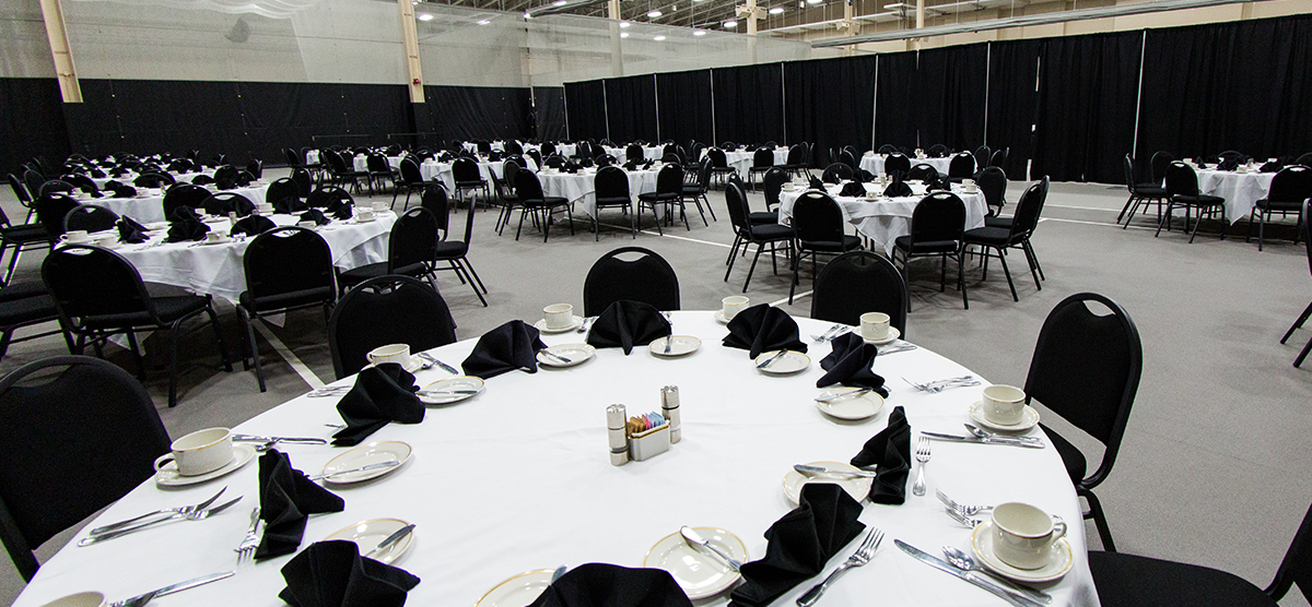 Round tables set for dining in the Fieldhouse at SentryWorld