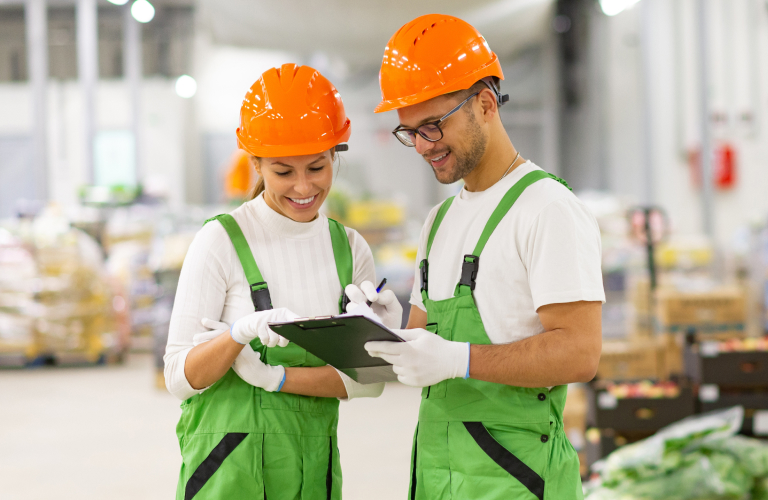 Food processing workers in orange hard hats.
