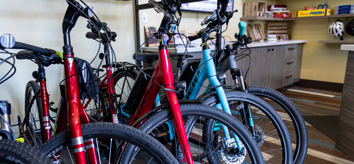 Bicycles parked indoors, with a counter and shelves in the background.