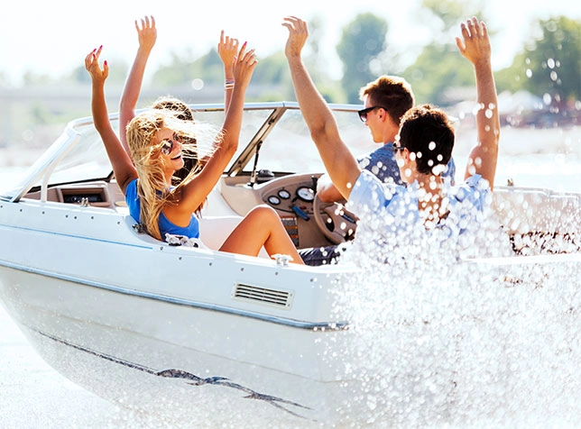 people riding in a boat with their hands up in the air