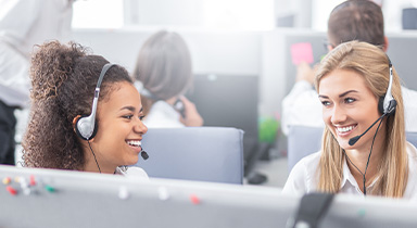 Two women on headsets working on computers