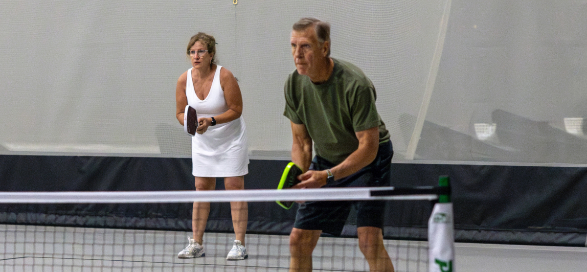 carousel-corporate-event-team-building-5-1200x556 Two pickleball players on a court at SentryWorld.