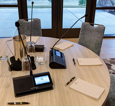 Microphones and notes pads on a table at SentryWorld for a corporate meeting